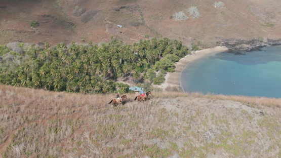 Aerial drone shot of two horse riders on the hills of Tahuata, Marquesas islands, French Polynesia, 2K7