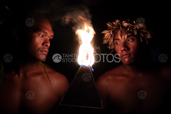 BORA BORA, PORTRAIT OF two POLYNESIAN dancers lighted by  FIRE TORCH AT NIGHT