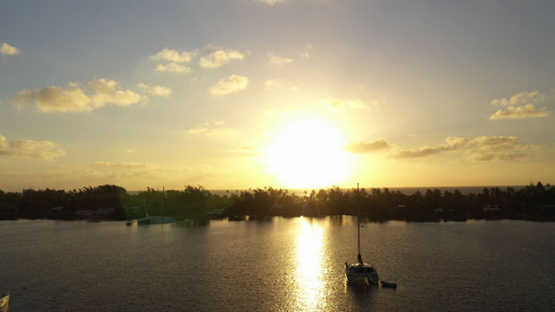 Fakarava, aerial view of Sail boats anchored under the sunset, 4K UHD