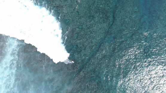Aerial view of Tahiti, surfers and wave of Taapuna pass, 4K UHD