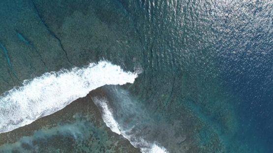 Aerial view of Tahiti, surf in the wave and barrier reef of Taapuna pass, 4K UHD
