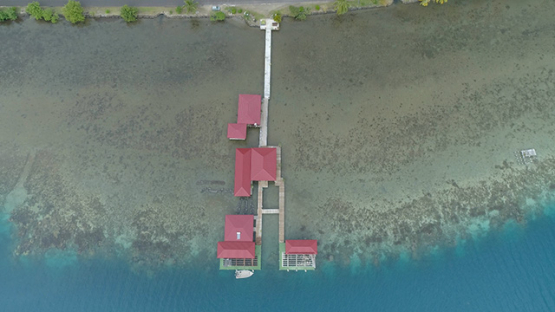 Tahaa, aerial view above the red roof of a pearl farm, 4K UHD
