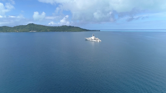 Bora Bora, aerial view of a yacht anchored in the lagoon, 4K UHD