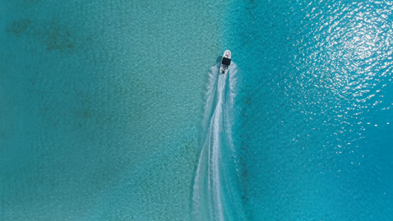 Bora Bora, aerial view  following a motor boat in the lagoon, 4K UHD