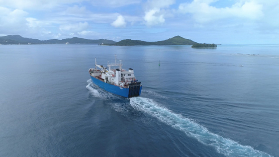 Bora Bora, aerial view of a cargo ship navigating in the lagoon, 4K UHD