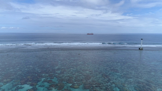 Bora Bora, aerial view of a cargo ship navigating on the ocean, 4K UHD