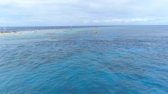 Rangiroa, aerial view of a motor boat and tourists in the Tiputa pass, 4K UHD
