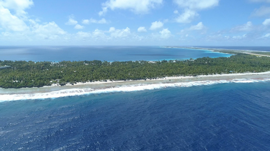 Tikehau, aerial view of barrier reef behind the village, 4K UHD