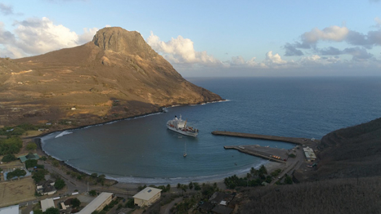 Ua Pou, aerial view of the village Hakahau and cargo ship docking in the bay, 4K UHD