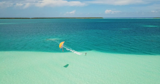 Tetiaroa 4k drone, aerial view of a kite surfer over the blue gradient of the lagoon