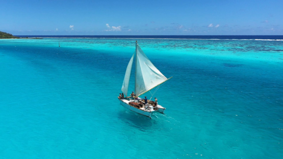 Aerial drone view of the lagoon of Moorea, traditional sailing outrigger