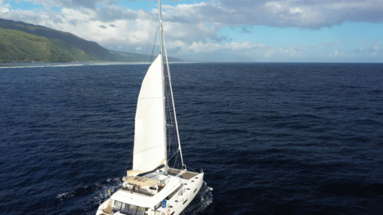 Tahiti, aerial view by drone of a sailing boat navigating on the ocean