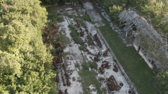 Aerial drone view of the island Makatea, man walking in the phosphate mill ruins, 2K7