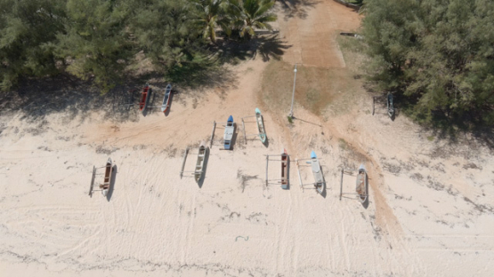 Rimatara, aerial view by drone of outrigger canoes on the sand beach of Amaru, 4K UHD