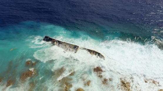 Wreck of fishing boat on the reef under the waves, 4K UHD