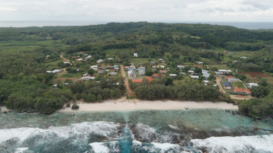 Rimatara, aerial view by drone of the village of Mutuaura and coastline, 4K UHD