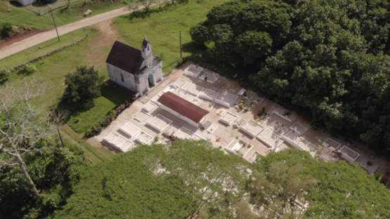 Gambier archipelago, aerial drone view of church and cimetery of Mangareva, 4K UHD