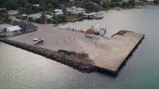 Gambier archipelago, aerial drone view of people playing on the dock of Mangareva, 4K UHD