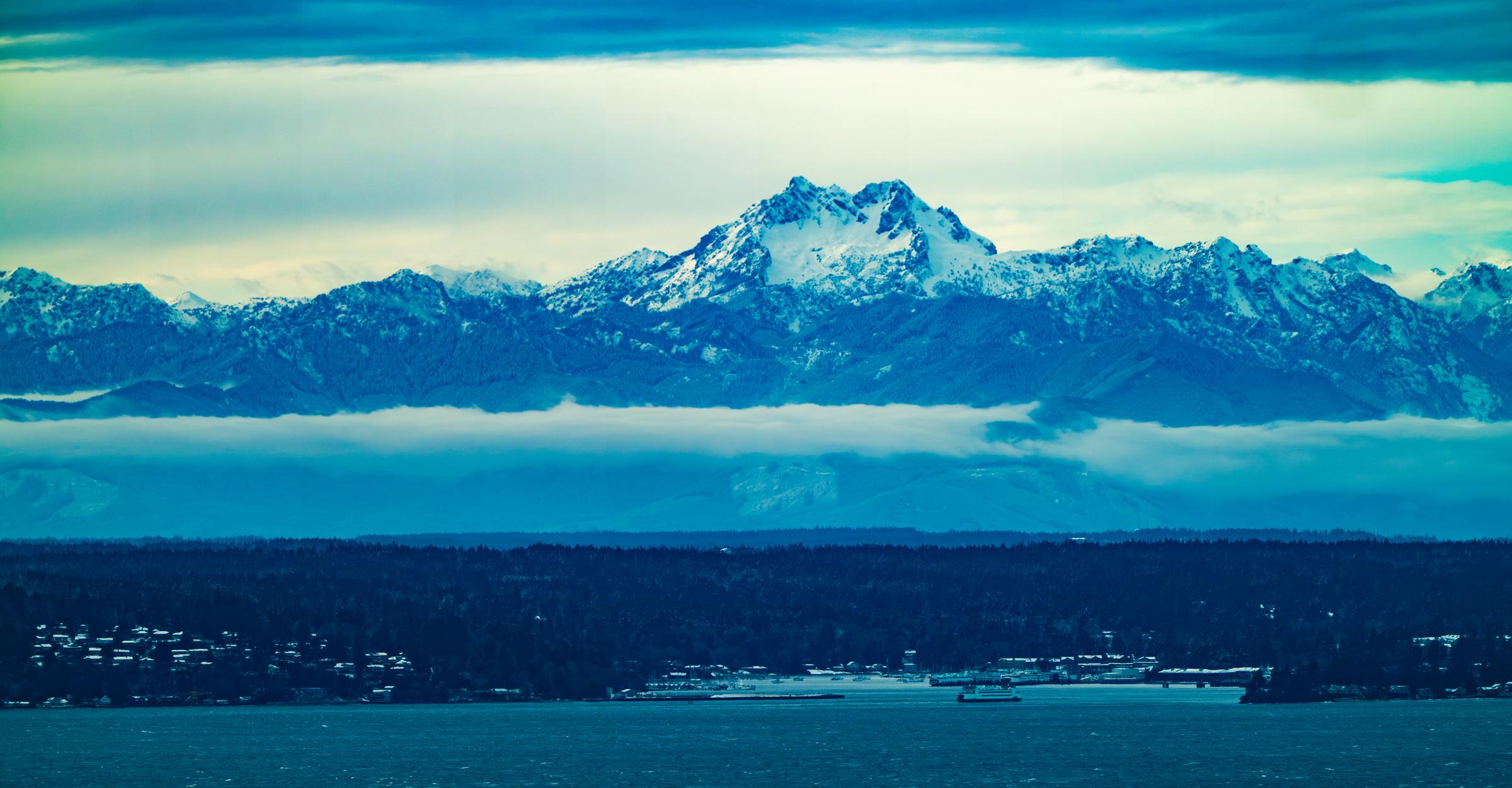 Snow-capped mountains viewed across a body of water Seattle Washington United States