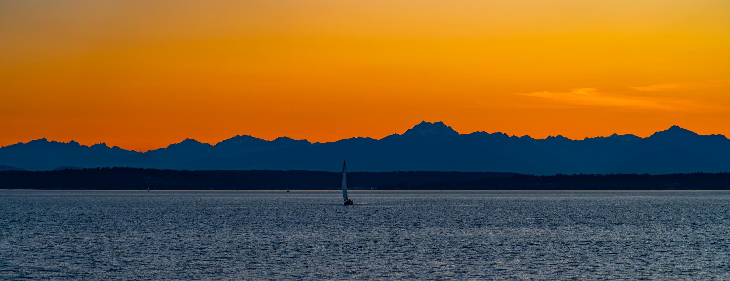 Sunset over the water with a sailboat Seattle Washington United States