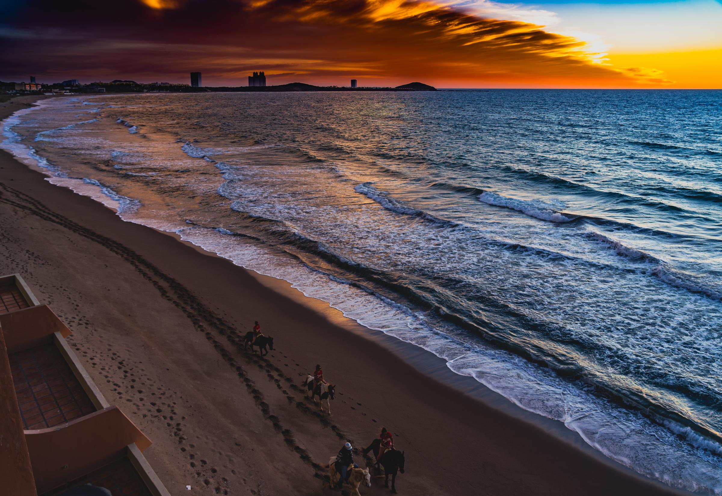 Horseback riding on the beach at sunset Mazatlan Sinaloa Mexico