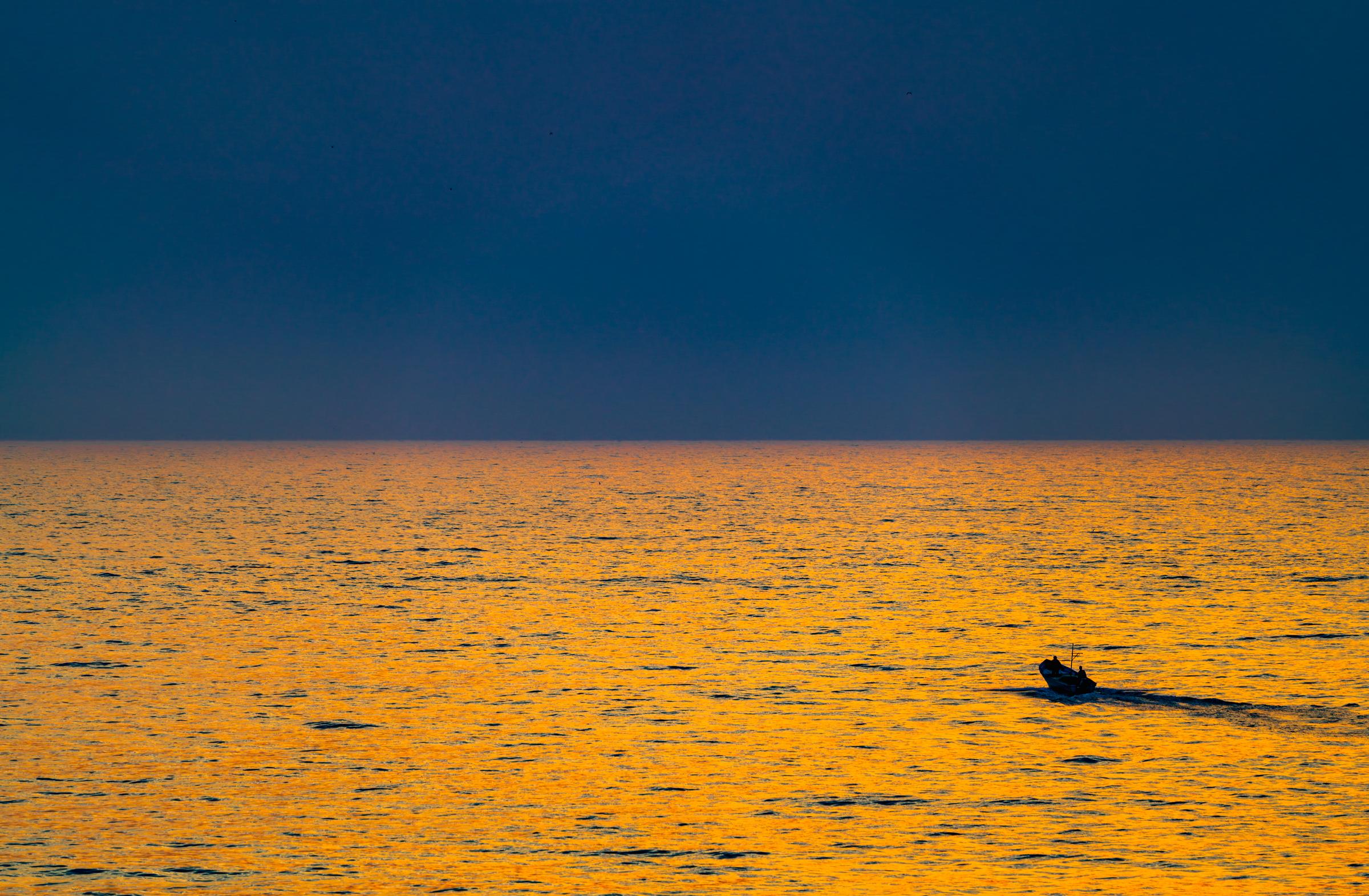 Sunset over the ocean with a distant boat Mazatlan Sinaloa Mexico
