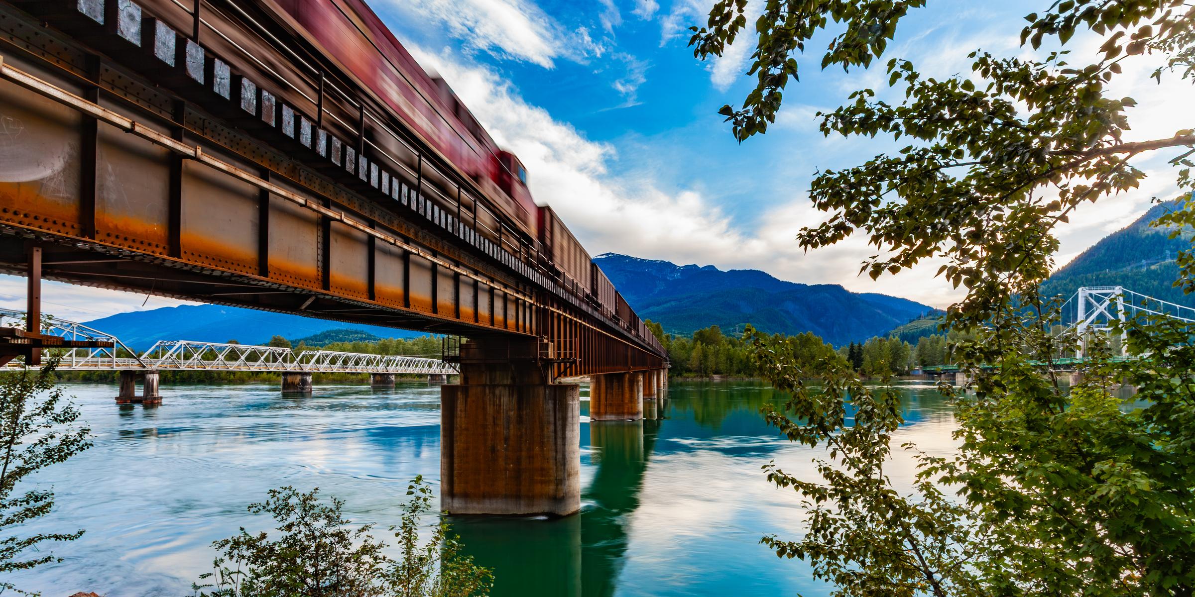 Train crossing bridge over river Revelstoke British Columbia Canada