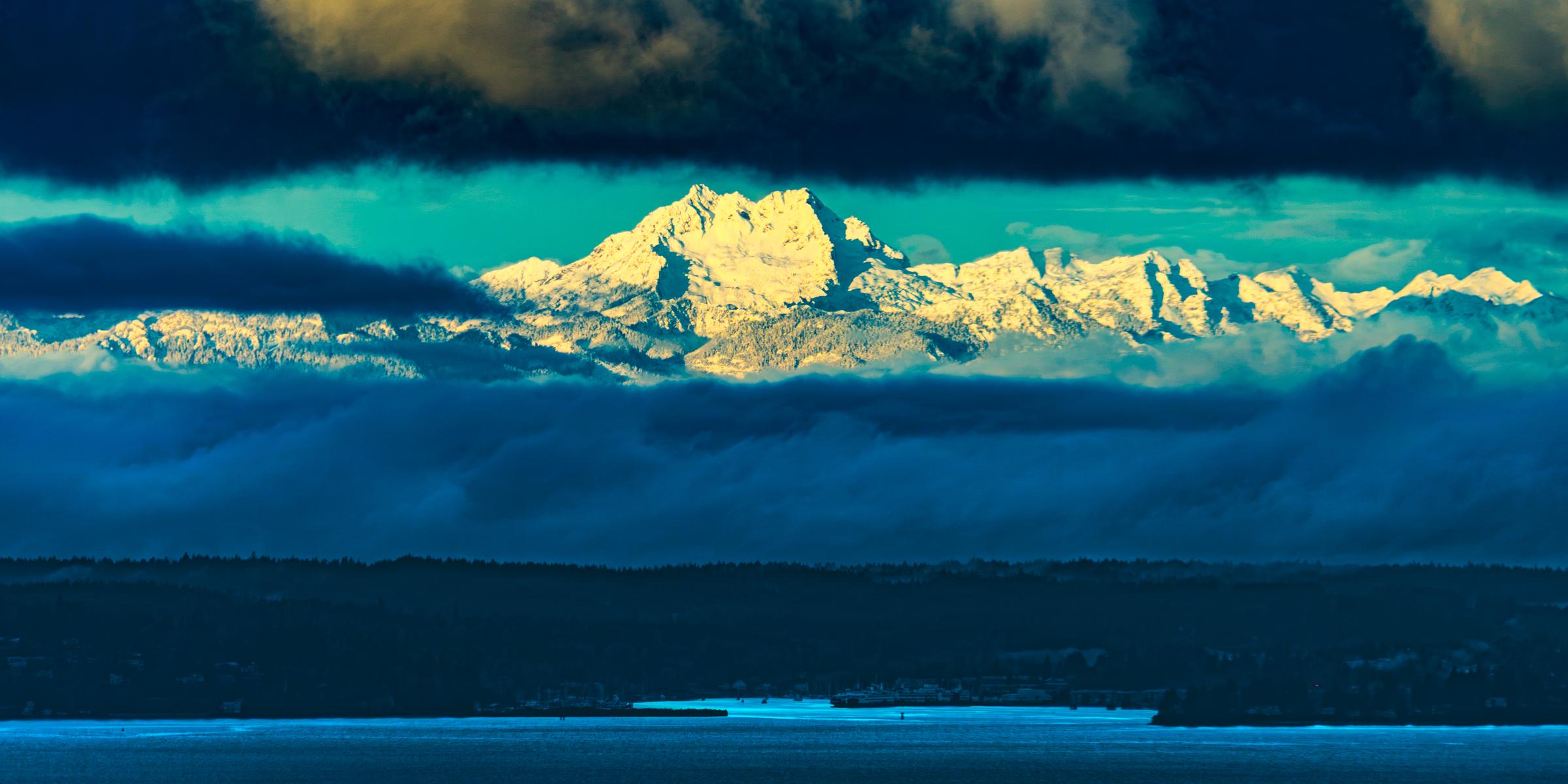 Snow-capped mountains behind a blue water body Seattle Washington United States