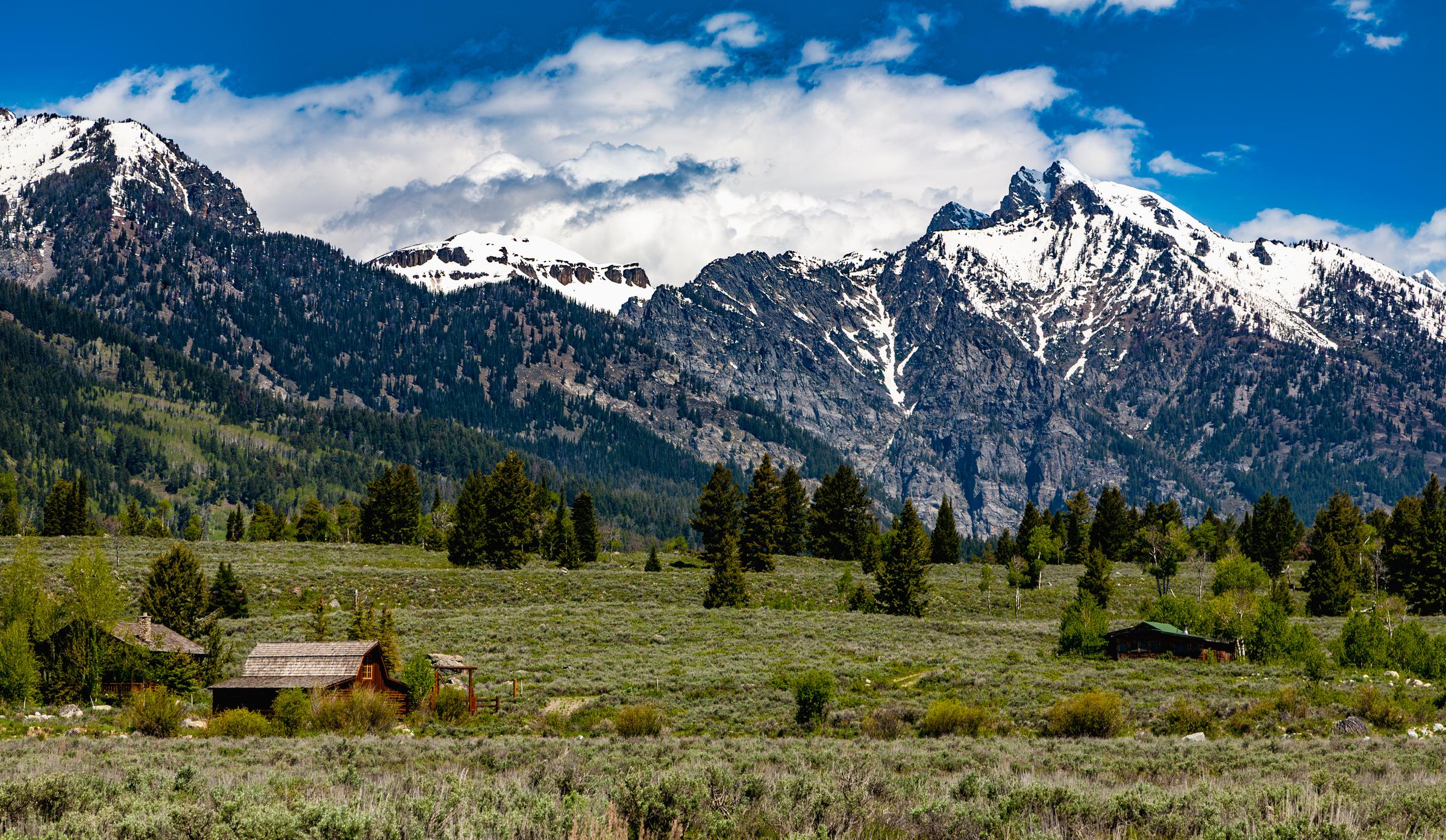 Snow-capped mountains and rustic cabins Moose Wilson Road Wyoming United States